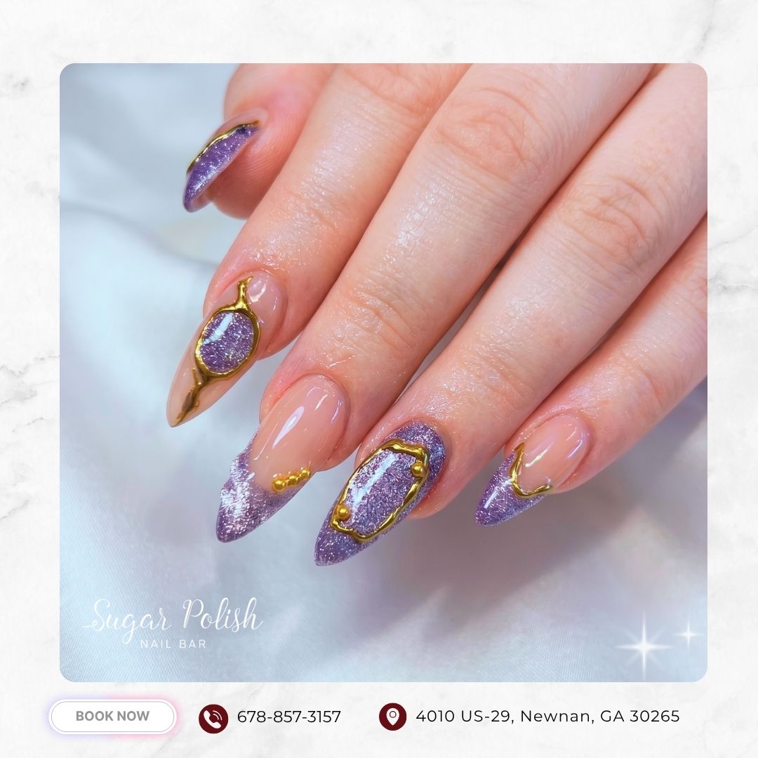 Purple glitter stiletto nails with gold frames, nude base, and gemstone-inspired design