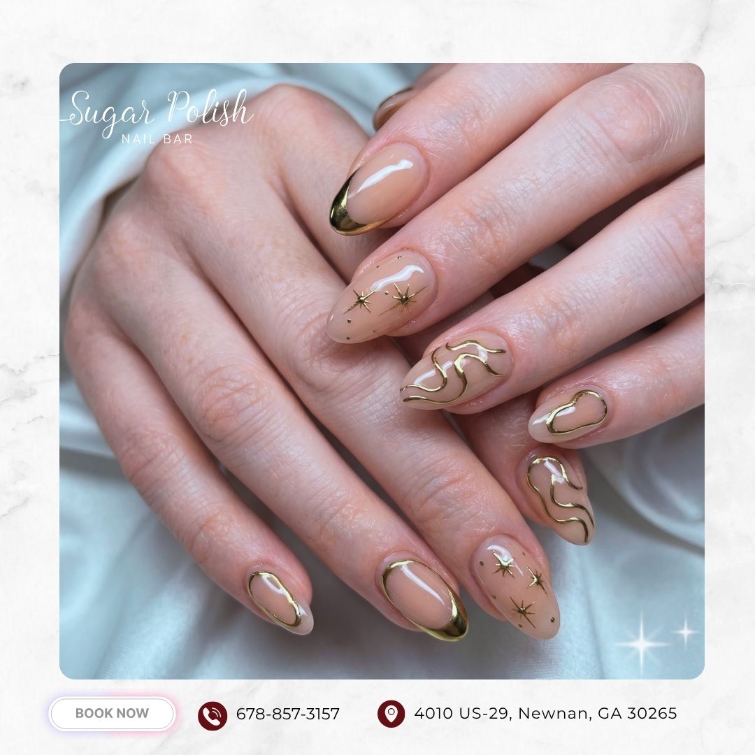 Nude almond nails with gold outline French tips, abstract swirls, and star accents