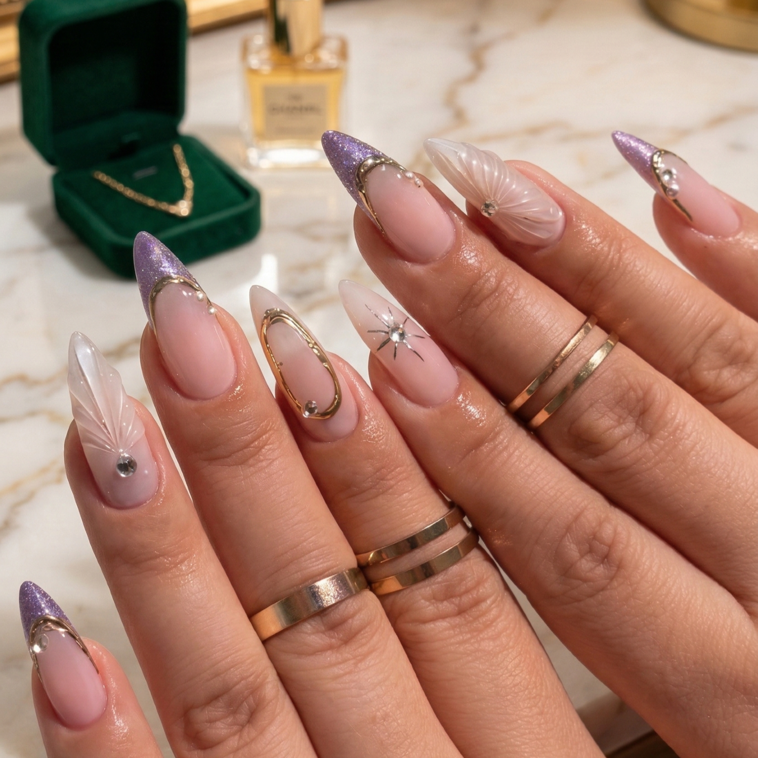 Almond nails with purple glitter French tips, 3D textured seashell art, gold frame accents, and celestial star details