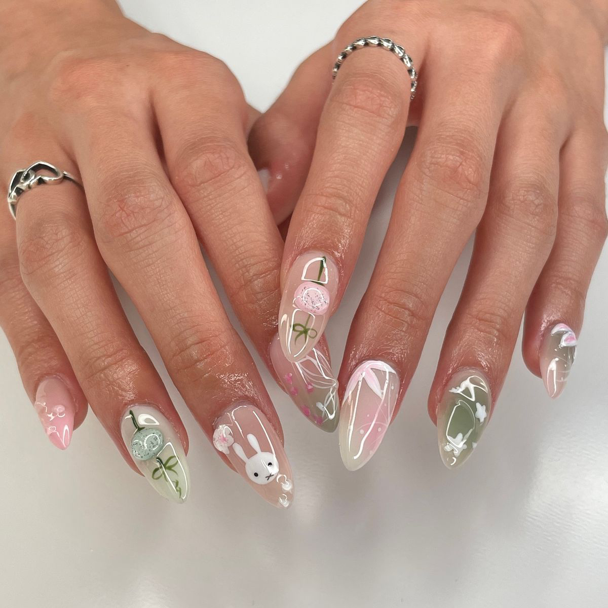 Pastel pink and green Easter nails with bunny and floral art.