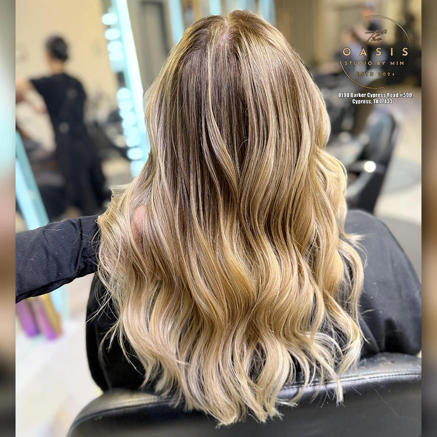 Golden blonde balayage with soft dimensional highlights, finished with beachy waves.