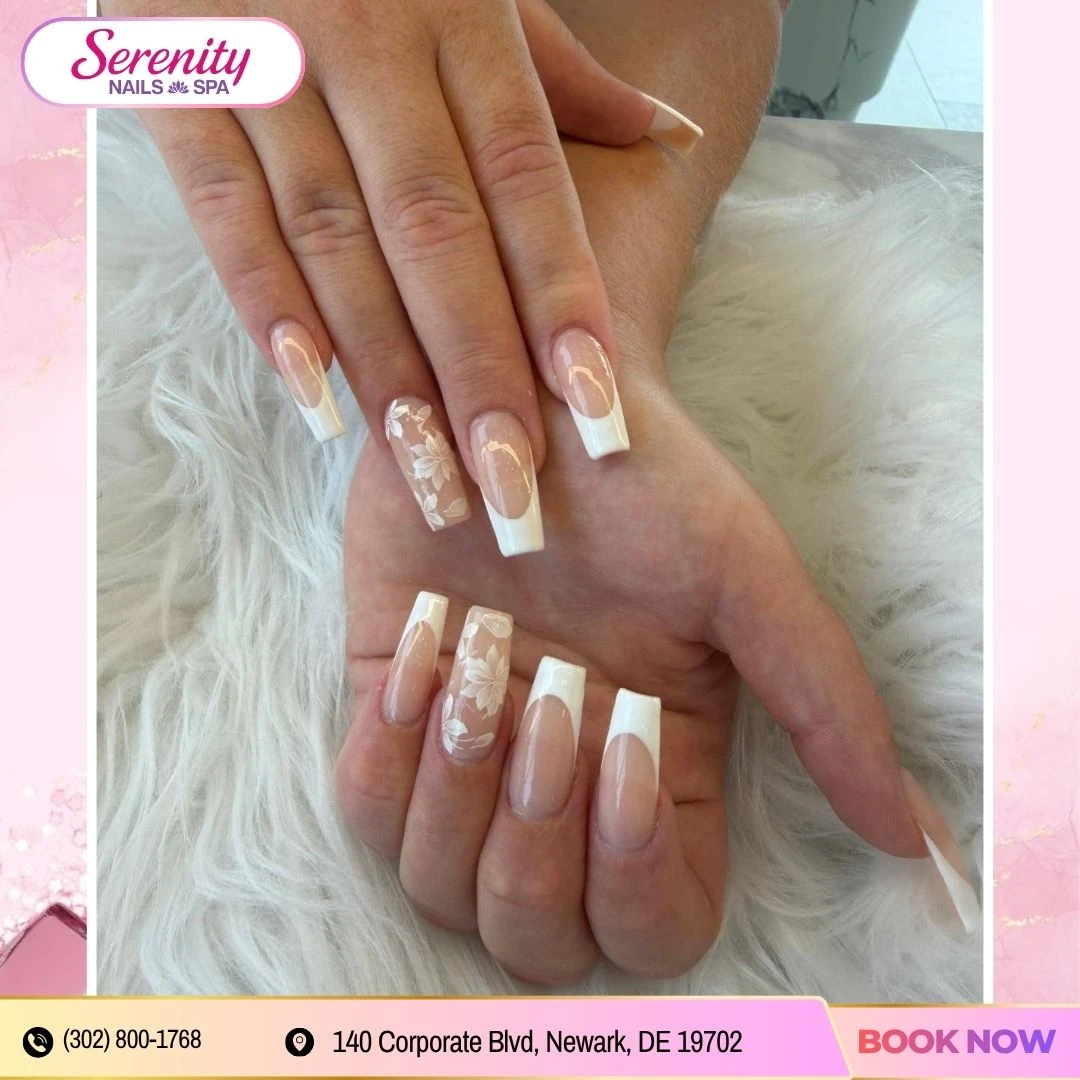 Long French manicure with delicate floral nail art at Serenity Nails & Spa